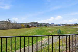 View of grassy yard featuring a mountain view and a rural view