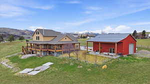 Rear view of house featuring an outdoor structure, a garage, a mountain view, a patio area, and an outbuilding