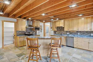 Kitchen featuring light stone counters, stone finish floors, and light wood finish cabinets