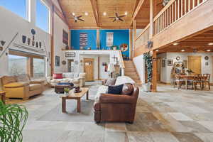 Living area featuring a high wooden beamed ceiling, ceiling fan, and recessed lighting