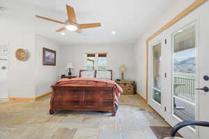 Bedroom with access to outside, ceiling fan, light stone finish flooring, and recessed lighting
