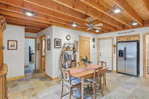 Dining space featuring light stone finish flooring and a ceiling fan