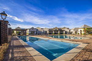 Community pool with a patio area and a residential view