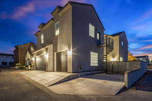 View of front facade with a garage, stucco siding, a balcony, and driveway
