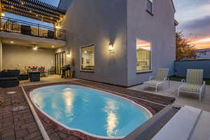 Pool at dusk with an outdoor pool, a patio area, an outdoor hangout area, and a pergola