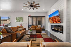 Living area featuring ceiling fan, recessed lighting, and a glass covered fireplace