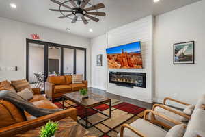Living area featuring recessed lighting, a ceiling fan, wood finished floors, and a large fireplace