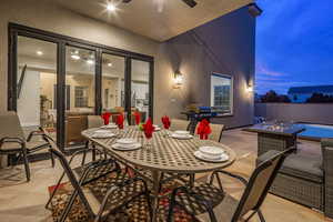 View of patio featuring outdoor dining area, ceiling fan, and area for grilling