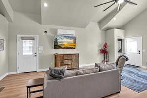 Living room featuring light wood-type flooring, a ceiling fan, vaulted ceiling, and recessed lighting
