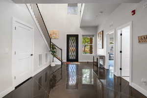 Foyer featuring granite floors and a high ceiling