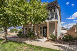 View of front of home with a balcony and stucco siding