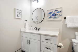 Half bathroom featuring vanity and toilet