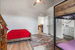 Bedroom with light wood-type flooring, ceiling fan, and vaulted ceiling