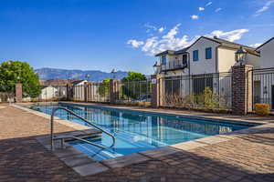 Community pool with a patio area, a mountain view, and a residential view