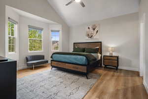 Bedroom with vaulted ceiling, light wood-style flooring, and ceiling fan
