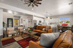 Living area with a ceiling fan, recessed lighting, a textured ceiling, and healthy amount of natural light