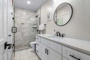 Bathroom featuring vanity, a stall shower, and recessed lighting