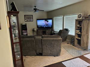 Carpeted living room with ceiling fan