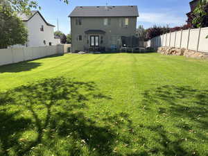 Rear view of property featuring a trampoline, a fenced backyard, a patio area, and stucco siding