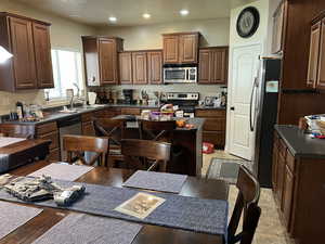 Kitchen with dark countertops, stainless steel appliances, recessed lighting, and dark wood finish cabinetry