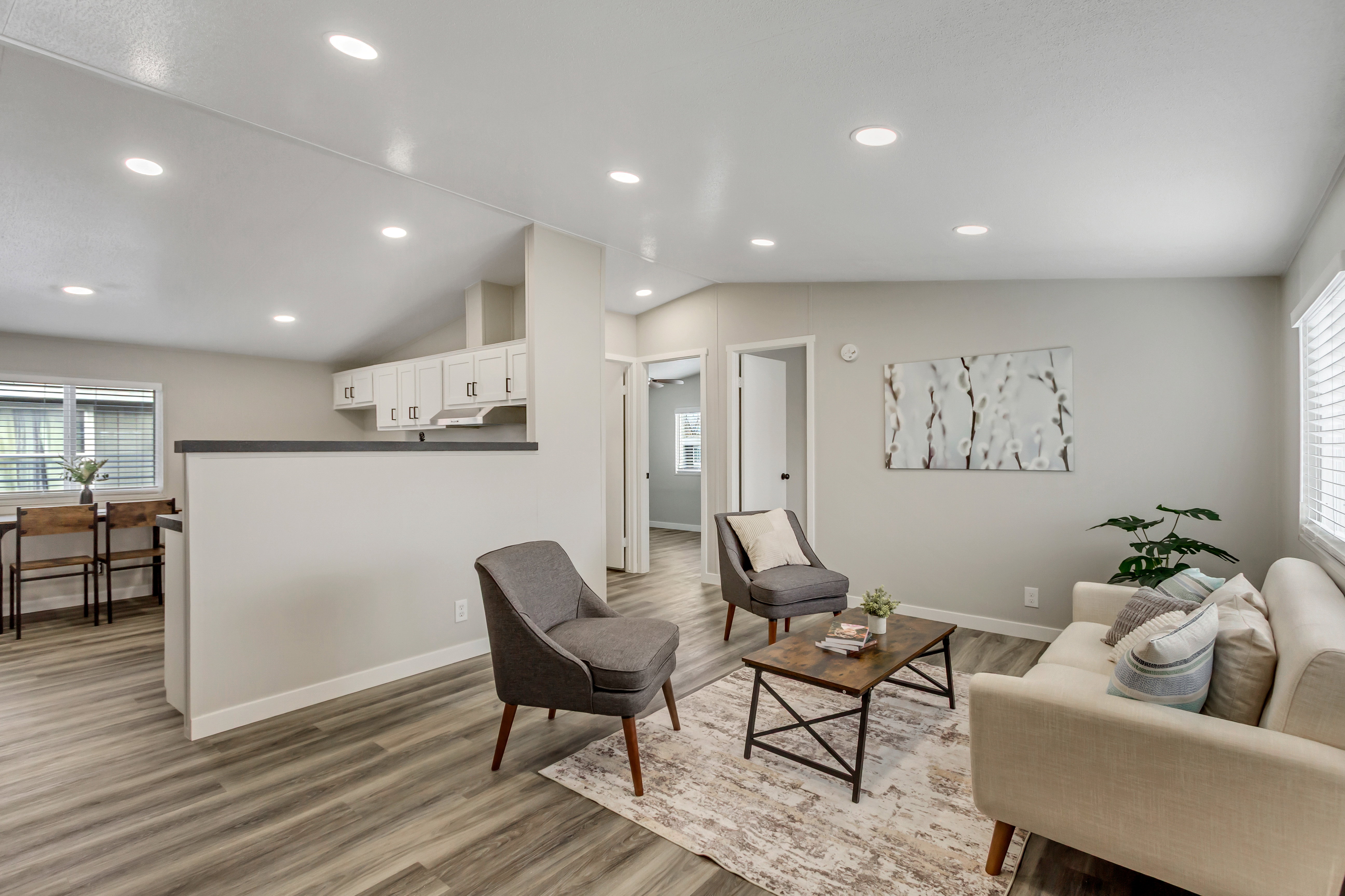 Living area featuring plenty of natural light, lofted ceiling, light wood-style flooring, and recessed lighting