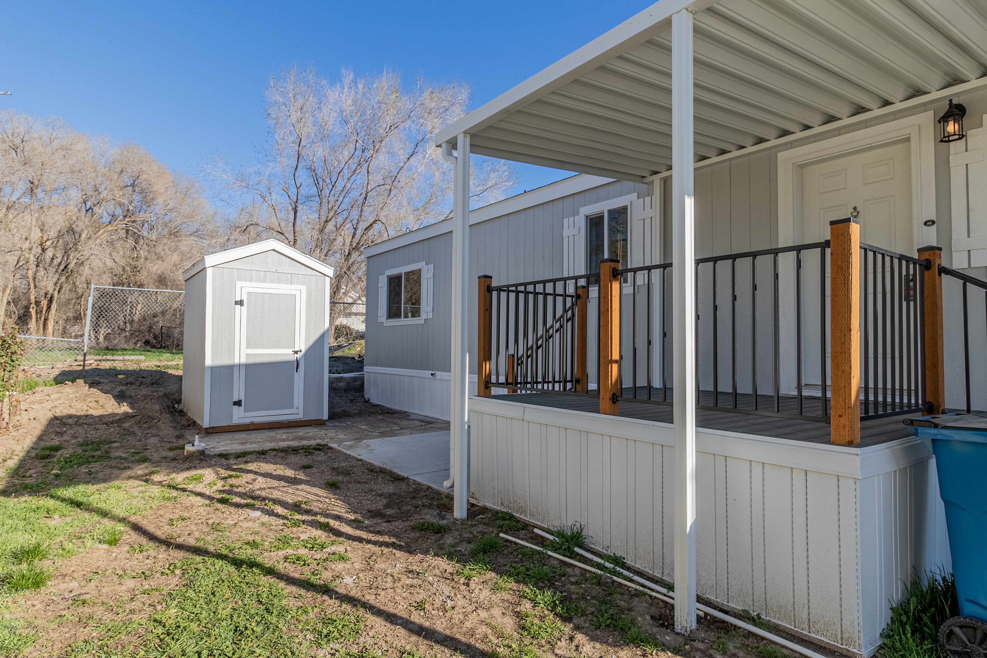 View of side of home featuring a storage shed