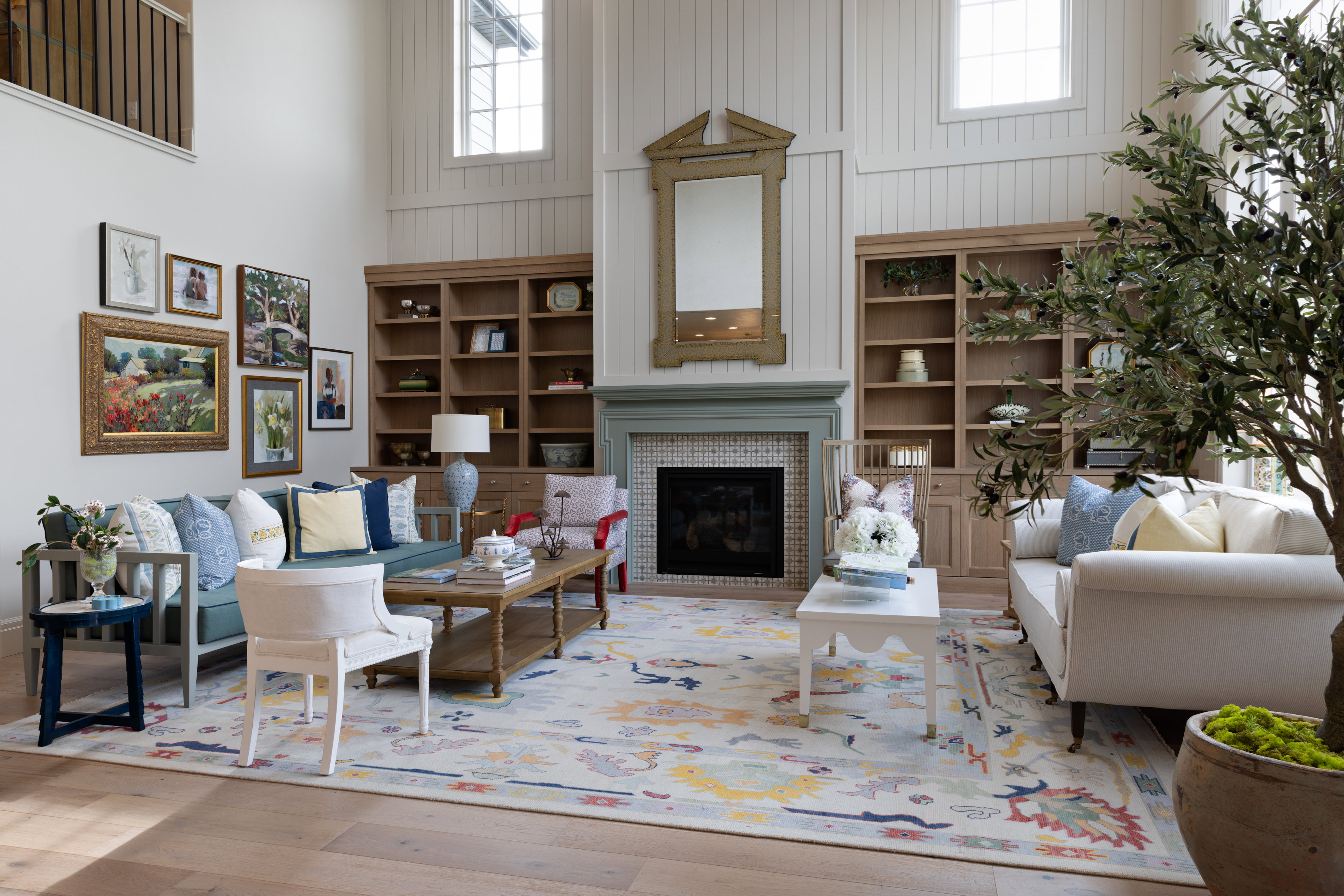 Living room with a high ceiling, a glass covered fireplace, wood-type flooring, and plenty of natural light