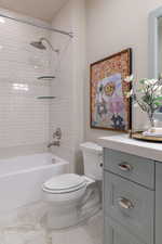 Full bathroom featuring vanity, shower / tub combination, and light marble finish flooring