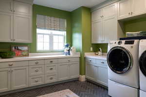 Laundry room featuring separate washer and dryer and cabinet space