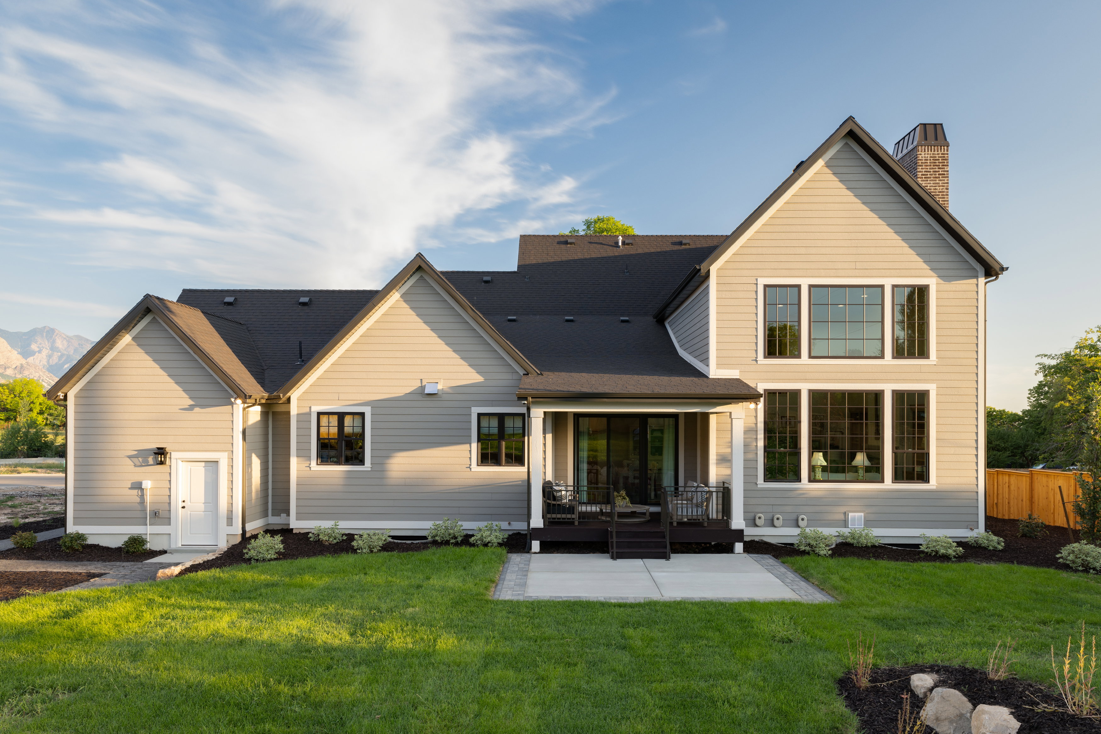 Rear view of property featuring a yard, a chimney, a patio area, and a mountain view