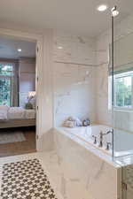 Ensuite bathroom with plenty of natural light, recessed lighting, and a bath