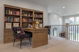 Home office with recessed lighting and light colored carpet