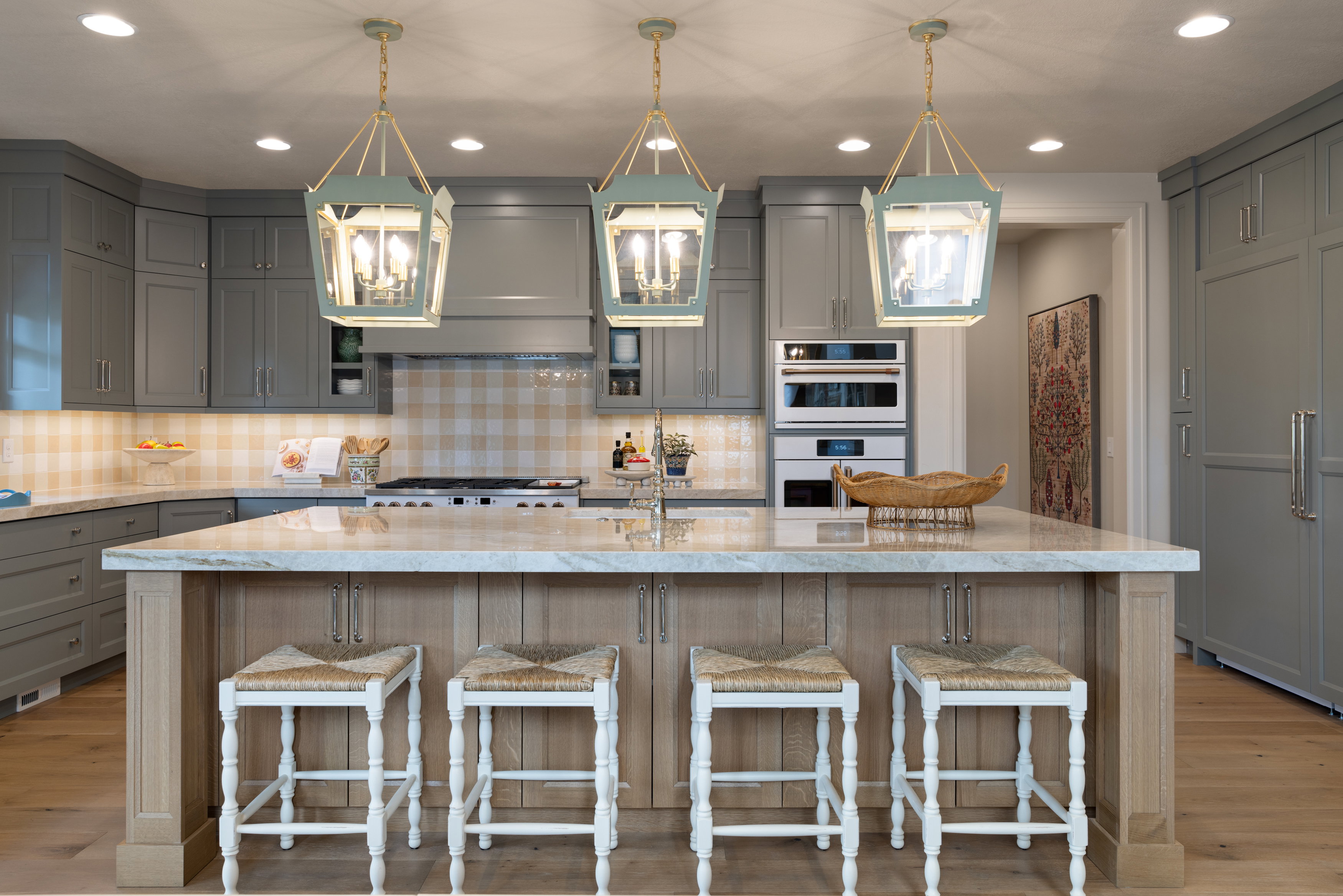 Kitchen with gray cabinets, light wood-style flooring, a kitchen bar, and light stone countertops