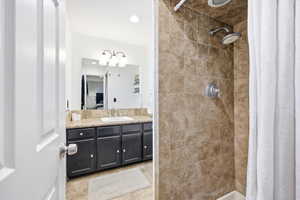Bathroom featuring a shower stall, ensuite bath, vanity, and recessed lighting