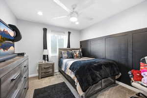 Bedroom with light colored carpet, ceiling fan, and recessed lighting