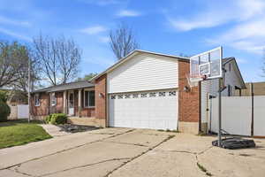 View of front of house featuring brick siding, driveway, a garage, and covered porch