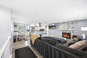 Living area featuring a fireplace, light wood-type flooring, and recessed lighting