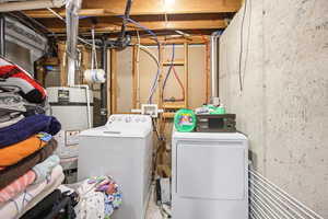 Laundry area with water heater and washing machine and dryer