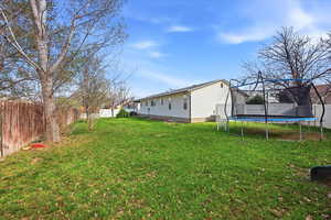 Fenced backyard with a trampoline