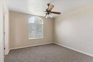 Unfurnished room featuring carpet floors and ceiling fan