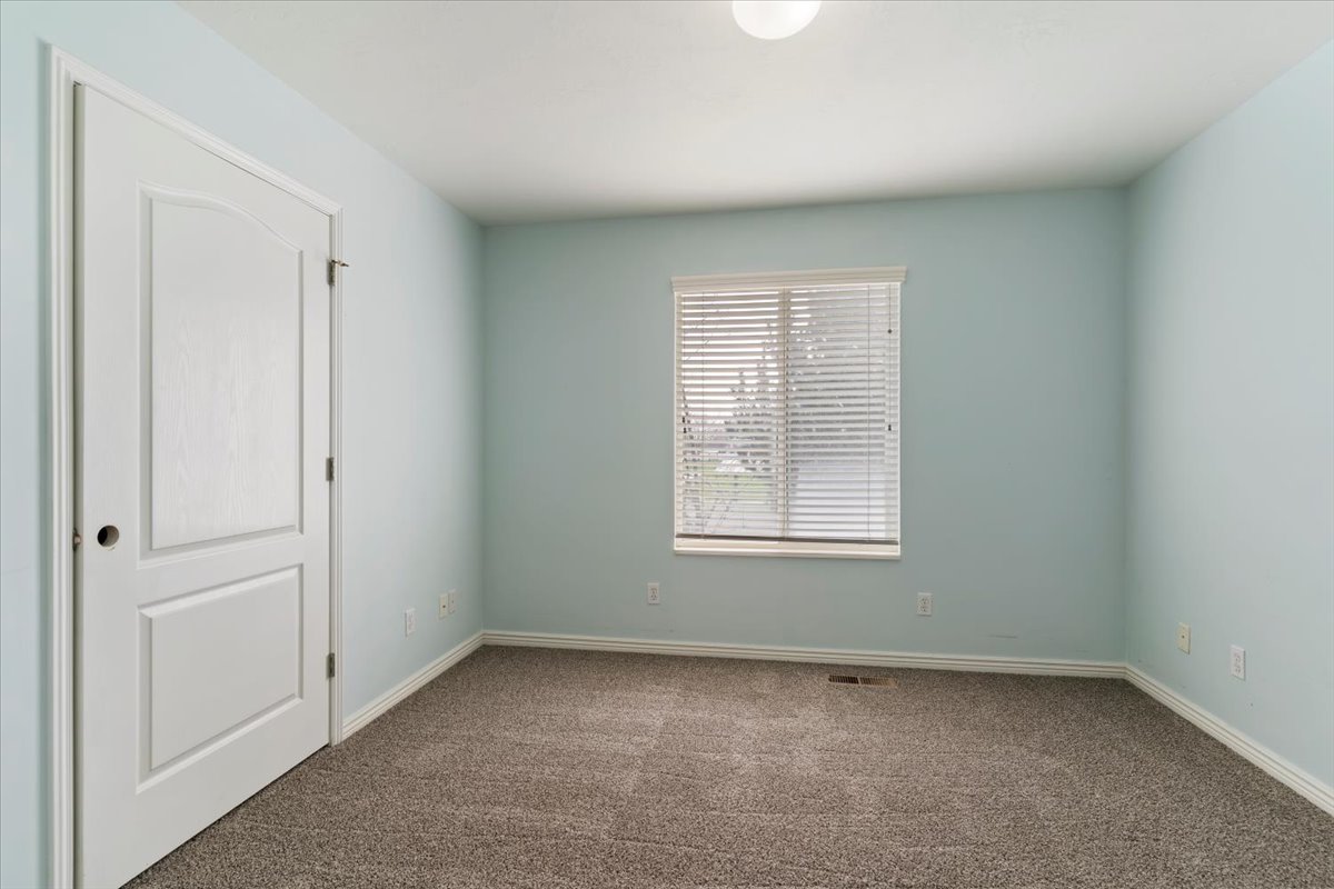 Unfurnished room featuring dark colored carpet and baseboards