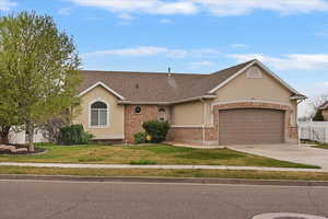 Ranch-style home featuring an attached garage, driveway, stucco siding, and roof with shingles