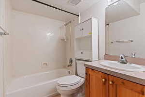 Bathroom featuring a textured ceiling, vanity, and washtub / shower combination