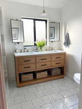 Full bath featuring double vanity and baseboards