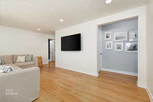 Living area featuring light wood finished floors, recessed lighting, and a textured ceiling