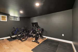 Exercise room with light wood-style flooring and baseboards
