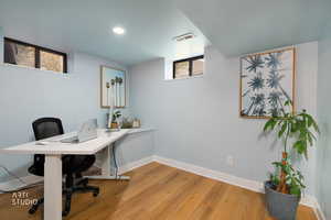 Office area with light wood-style flooring and healthy amount of natural light