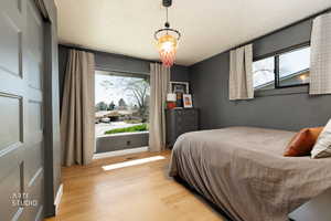 Bedroom featuring a textured ceiling, multiple windows, and light wood finished floors