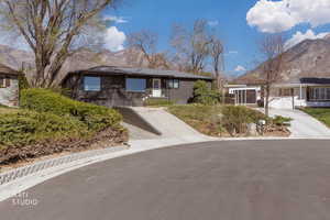 Ranch-style house featuring a mountain view, concrete driveway, and brick siding