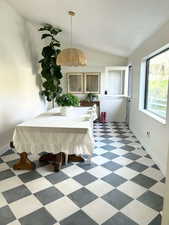 Dining room featuring vaulted ceiling and dark flooring